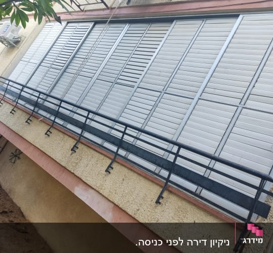 תריסים לבנים על קיר חיצוני של בניין